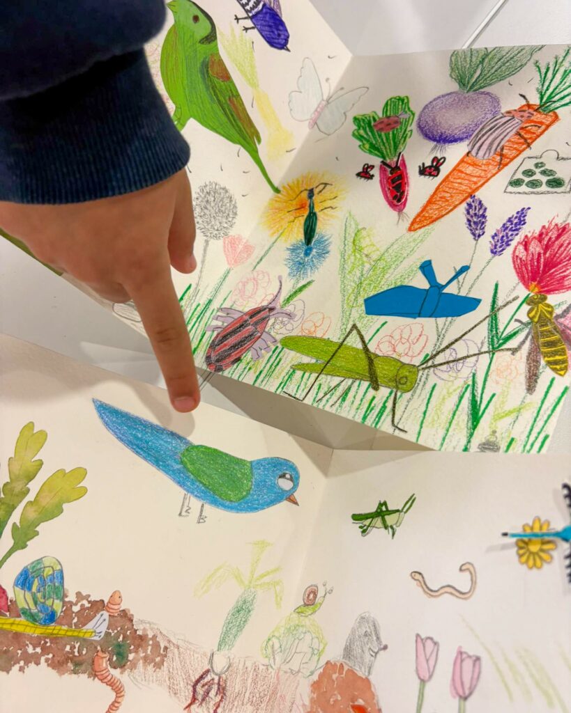 Enfant nous montrant le bel oiseau bleu qu'elle a dessiné